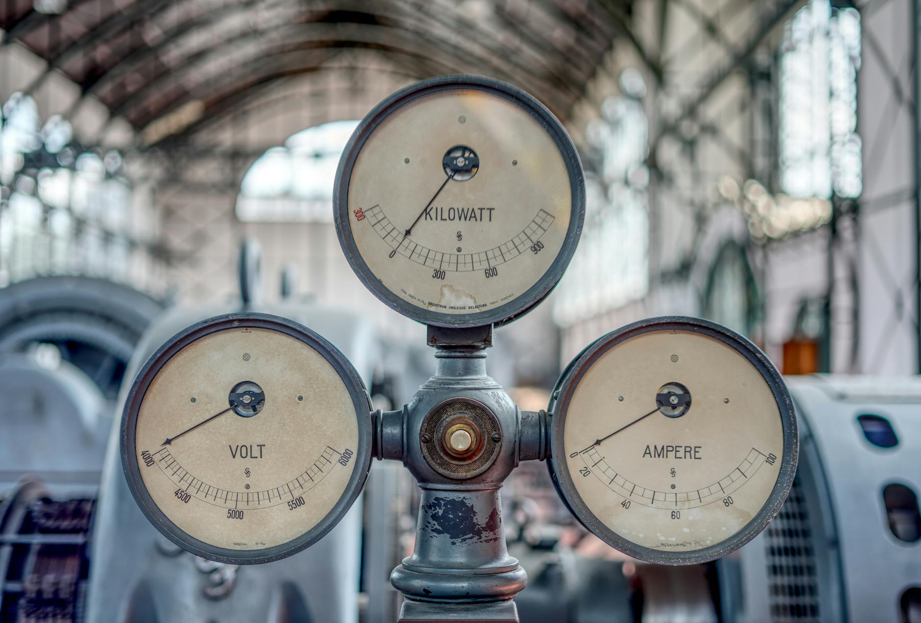 Analogowe wskaźniki napięcia, prądu i mocy w starej hali przemysłowej