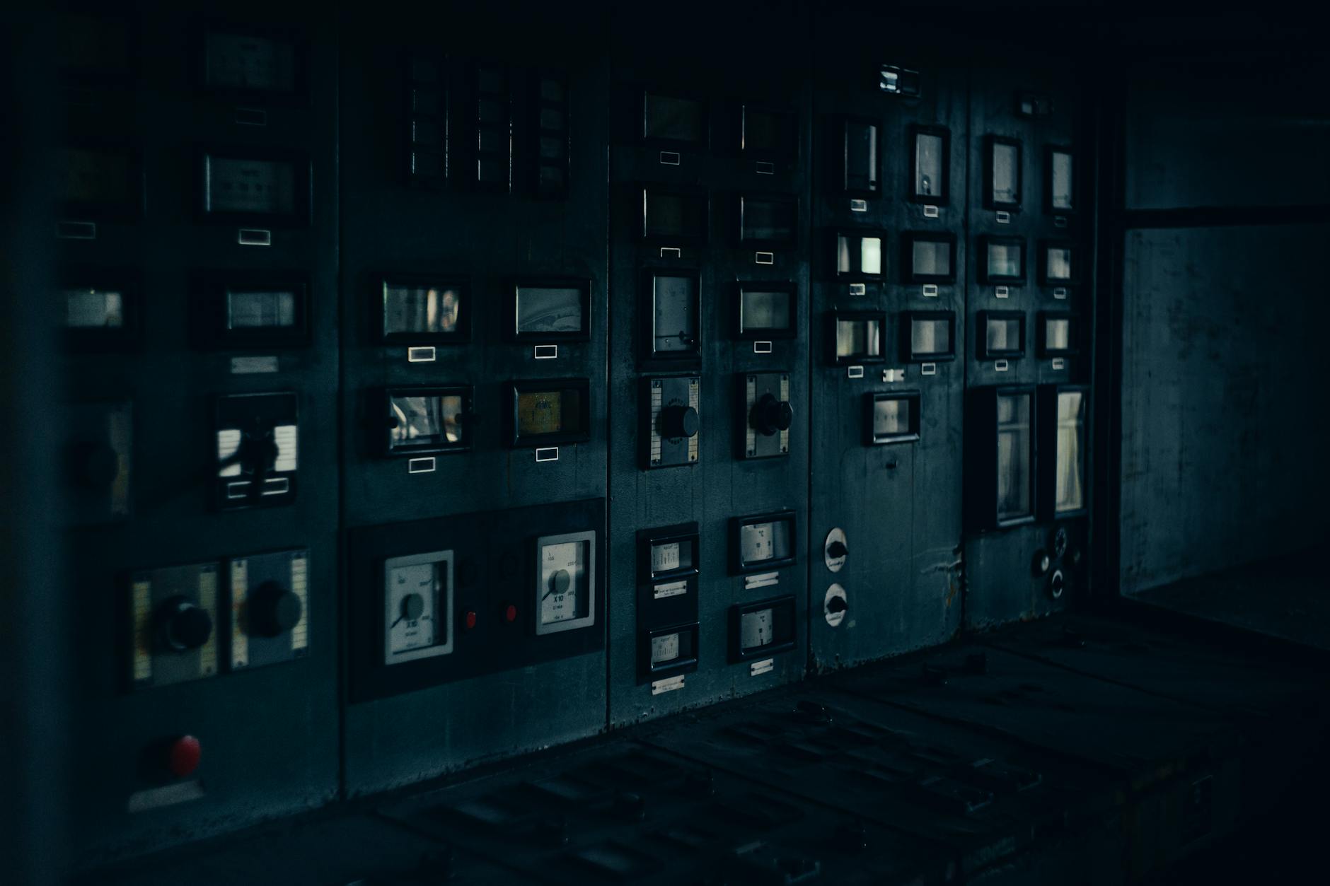 Stary panel sterowania z analogowymi licznikami w hali przemysłowej