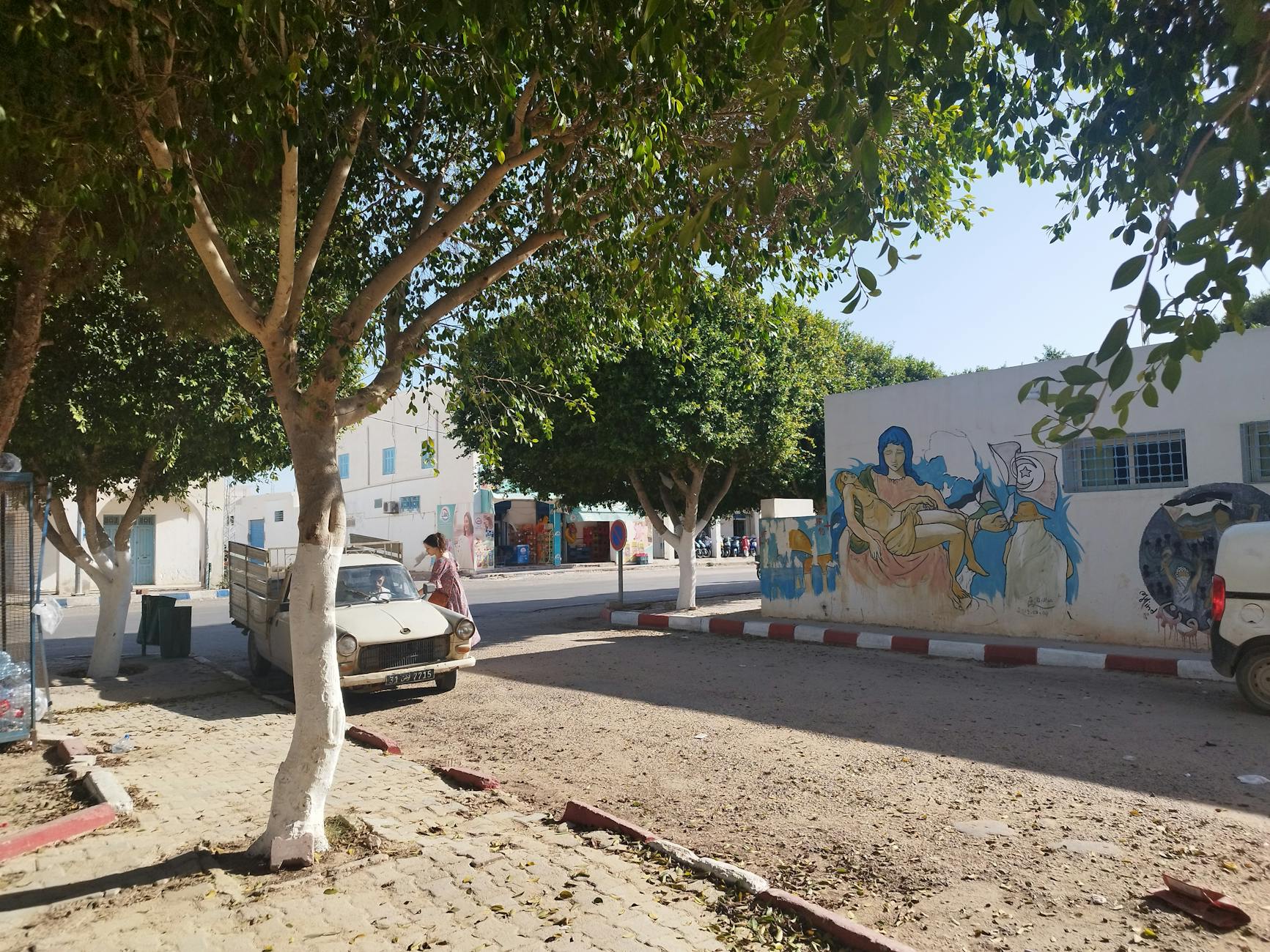 Ulica w Médenine z drzewami i kolorowymi muralami