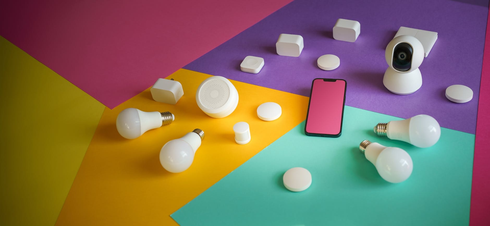 Kolorowe urządzenia smart home i czujniki IoT obok smartfona
