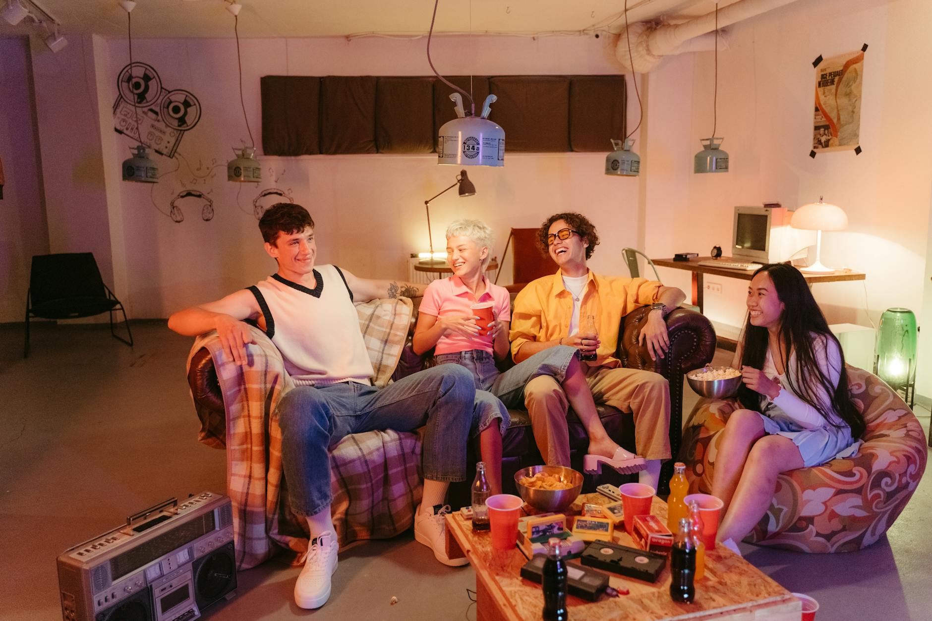Jak przygotować się do escape roomu w Warszawie, żeby naprawdę cieszyć się rozgrywką Czwórka przyjaciół bawi się razem w pokoju, jedząc przekąski